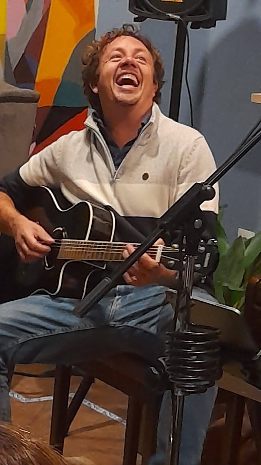 Ken laughing while playing guitar