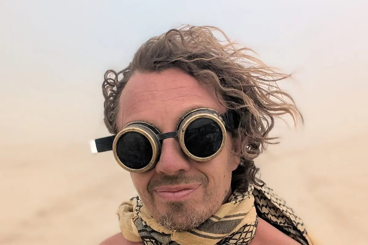 Ken Hellem in the desert wearing goggles and a scarf