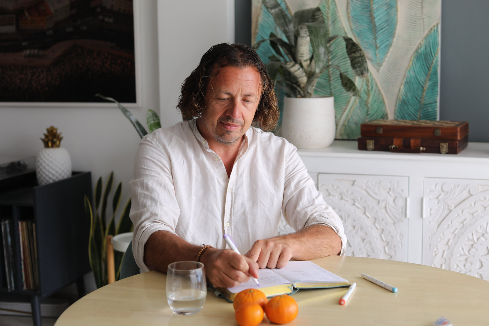 Kenneth writing in a journal at his table in Malaga, pen in hand